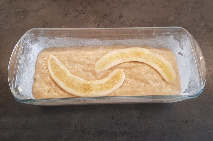 Banana bread avant cuisson : Préparation versé dans un moule à cake et 3ème banane déposé par-dessus en décoration 