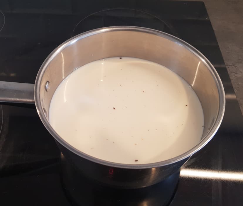 Lait avec sucre en cuisson dans une casserole en inox