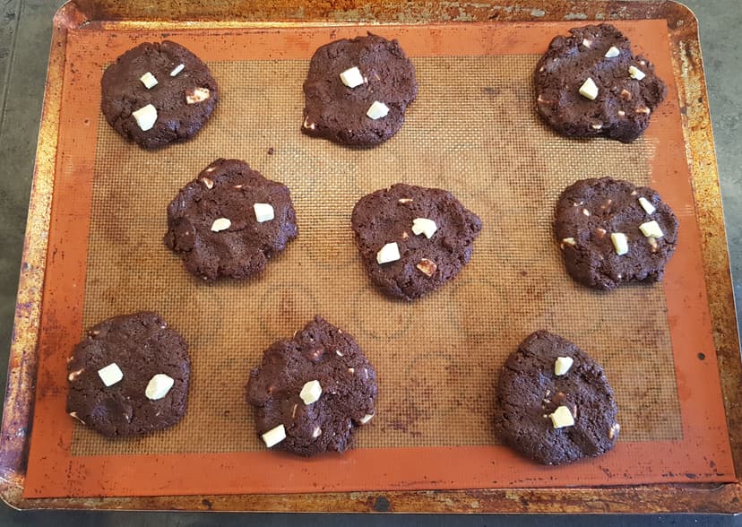 Pâte à cookies déposé en plusieurs boule puis étalé sur une plaque de cuisson 