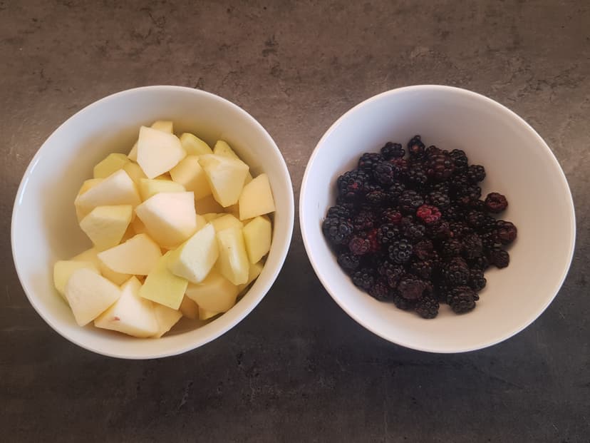 Pommes coupées en morceaux et mûres rincées, déposés respectivement dans des bols 