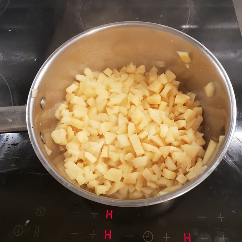 Pomme et coing coupés en dés en cuisson dans une casserole