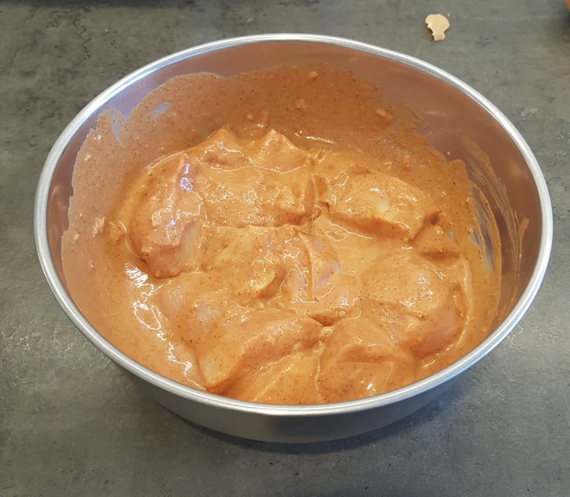 Marinade avec les morceaux de filets de poulet dans un saladier 