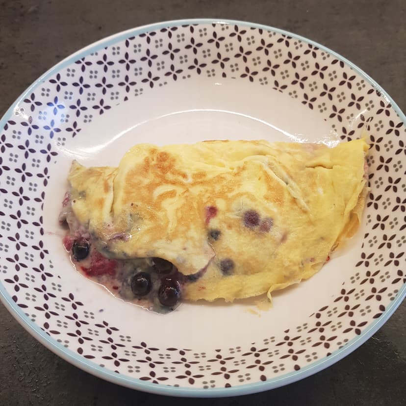 Omelette sucré aux fruits rouges dans une assiette avant dégustation 